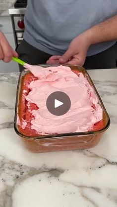 a man is spreading icing on a cake in a pan