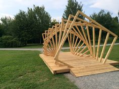 a wooden structure sitting on top of a lush green field