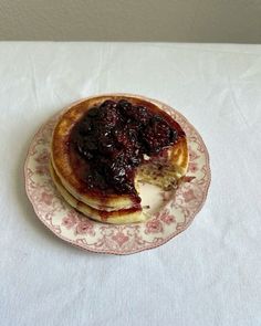 a plate topped with pancakes covered in blueberry compote