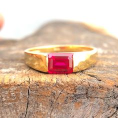 a close up of a gold ring with a red stone in it's center