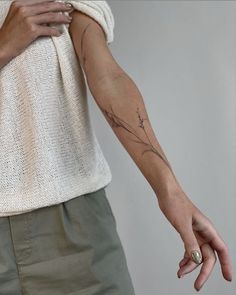 a woman's arm with a tattoo on it and her hand in the air