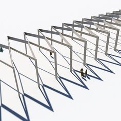 a group of people standing next to each other in front of a white wall with long poles