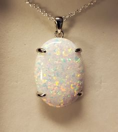 "Huge White Opal 18x25mm With Multicolored Fire, See Video! 925 Sterling Silver Pendant, 20\" Sterling Chain. Chain Length Options Available By Messaging Seller At Time Of Purchase. Gift Box Included. *We Only Have White, But Light Blue Coming! We Will Also Have A Split Bail Option Soon." White Oval Pendant With Polished Finish, White Oval Pendant Necklace With Polished Finish, White Oval Necklace With Polished Finish, Sterling Silver White Cabochon Necklace, White Cabochon Sterling Silver Necklace, White Oval Necklace With Large Pendant, White Hallmarked Oval Pendant Jewelry, White Sterling Silver Necklace With Polished Finish, White Polished Sterling Silver Jewelry