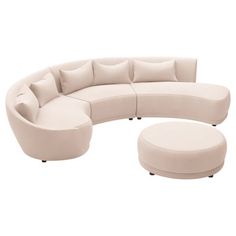 a curved couch with pillows on it and a footstool in front of it