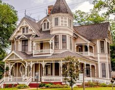 an old victorian style house with white trim