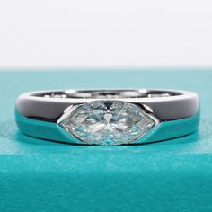 a diamond ring sitting on top of a blue box