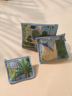 three decorative pillows sitting on top of a table