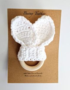 a white crocheted ring holder on top of a brown card with the words bunny ticker