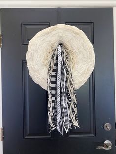 a black door with a white hat hanging on it