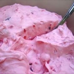 a bowl filled with pink ice cream next to a spoon