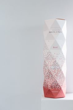 a white box with pink and red sprinkles sitting on top of a shelf