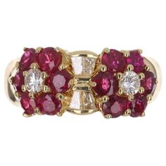 A fine quality ruby and diamond wide band in 18K yellow gold. Twelve, vivid, red rubies highlight the sides of the band and create an eye-catching design. Brilliant round and tapered baguette diamonds accent the well-designed ring. This is an elegant band with full finger coverage. Smooth and ideal for everyday wear. Setting Style: Cluster Setting Material: 18k Yellow Gold Main Stone: Ruby Shape: Round Estimated Weight: 1.44-Carats Clarity: Transparent Color: Red Luster: Excellent Treatment: Natural Secondary Stones: Diamond Shape: Brilliant Round/Tapered Baguettes Total Diamonds: 6 Weight: 0.44cts Clarity: VS Color: G-H Luster: Excellent Wide Gold Band, Van Cleef And Arpels, Baguette Diamonds, Colombian Emeralds, Ruby Diamond, Van Cleef, Baguette Diamond, Natural Ruby, Wide Bands