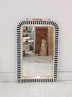 a mirror that is sitting on top of a table in front of a white wall