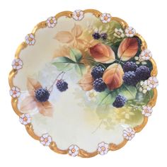 a decorative plate with flowers and berries on it