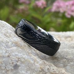 a black ring sitting on top of a rock