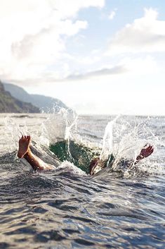 a person is swimming in the ocean with their feet out and one hand on his stomach