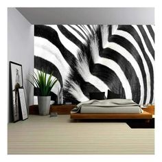 a bedroom with a zebra print wallpaper in the corner and a plant on the bed