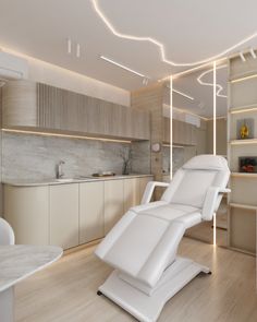 a white reclining chair sitting on top of a hard wood floor next to a kitchen