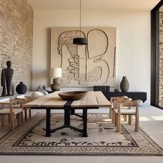 a table and chairs in a room with brick walls, artwork on the wall and rug