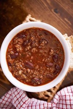 a bowl of chili next to bread on a wooden table with the title homemade chili