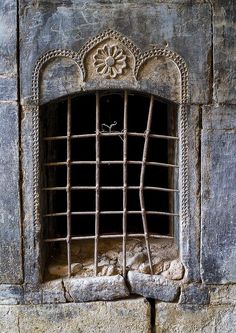 an old window with iron bars on it