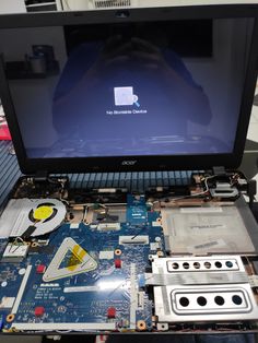 an open laptop computer sitting on top of a table with its motherboard removed from it