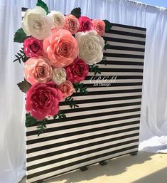 a black and white striped backdrop with pink, red, and white flowers on it