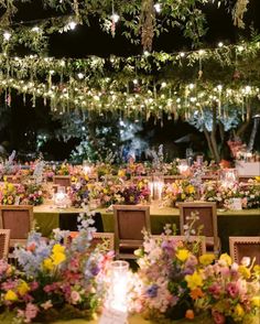 an outdoor dining area is decorated with flowers and candles