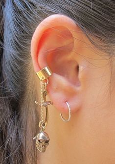 https://www.martymagic.com/skull-and-scimitar-ear-cuff-bronze/ Skull Earring, Ear Cuff Chain, Pirate Accessories, Pirate Jewelry, Types Of Ear Piercings, Jewelry Skull, Jewelry Ear, Buried Treasure, Wrap Earrings