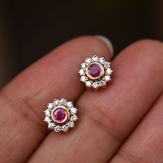 "Crafted in solid 14k gold, these earrings are bezel set with natural round Ruby in the center, with a natural diamond floral halo. Perfect pair for everyday wear or for a special occasion, a must-have piece for every wardrobe. A great gift for a July born. Can be worn in almost all piercings like nose, tragus, helix, lip, lobe, flat, conch, brow, dermal, etc * Flower Size : 7.5 mm * Gemstone 1: Natural Diamond * Diamond Wt. : 0.20 Ct * Color / Clarity : H-I, Vs-Si * Gemstone 2: Ruby * Stone Wt. 14k Gold Diamond Gemstone Earrings, Diamond Flower-shaped Gemstone Earrings, Yellow Gold Earrings With Bezel Setting For Wedding, Rose Gold Diamond Earrings With Gemstone, Diamond Gemstone Earrings Round Cut, White Gold Flower Shaped Earrings With Gemstones, Yellow Gold Gemstone Flower-shaped Earrings, 14k Gold Diamond Earrings With Bezel Setting For Wedding, 14k Gold Bezel Set Diamond Earrings For Wedding