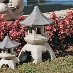 two stone lanterns sitting in the grass next to flowers