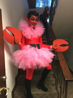 a woman dressed in pink and red is sitting on the stairs