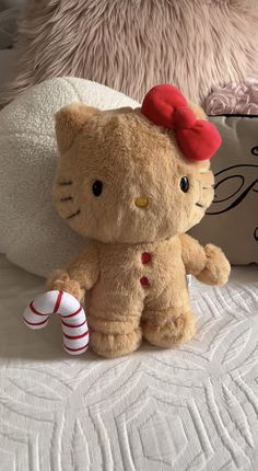 a teddy bear with a red bow sitting on a bed