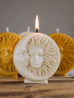 a candle that has some kind of face on it with two candles in the background