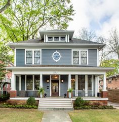 a blue house with white trim on the front porch and steps leading up to it