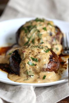 a white plate topped with meat covered in gravy