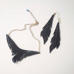 This is a handcrafted leather bin necklace with hand painted dot accents. This is a set so there are matching feather styled boho earrings in the same leather and hand painted accents. Measurements:Necklace bib 5 1/4" x 2"Chain length 16" - 18"Earrings 5" long x 1 1/4" widePainted accents gold and teal Gold Flecks, Necklace And Earring Set, Bib Necklace, Handcrafted Leather, Brass Earrings, Leather Jewelry, Style Moderne, Boho Earrings, Blue Leather