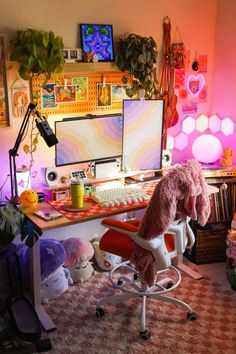 a computer desk with a pink stuffed animal sitting on it's chair in front of two monitors