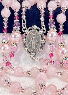 "Magnificent rosary made with 8mm genuine Madagascar Rose Quartz gemstones, Austrian crystal pearls, Preciosa crystals and silver plated embellishments. This rosary is very dressy and formal, yet perfect for every Sacramental occasion, First Communion, Wedding, Confirmation, or that special gift that says, \"I'm thinking of you\". If you're wanting Swarovski pearls, I think you'll find the quality of these Rosaline pearls to match them in weight, color, and bright luster finish! I use these inte Cheap Elegant Rosary As A Gift, Handmade Rosary Bracelet With Round Beads For Wedding, Elegant Pink Wedding Rosary Bracelet, Elegant Pink Rosary Bracelet For Wedding, Pink 8mm Beads Jewelry For Wedding, Spiritual Wedding Jewelry With 8mm Beads, Spiritual 8mm Beads Jewelry For Wedding, Spiritual Beaded Rosary Bracelet For Wedding, Kailey Core