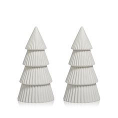 two white ceramic christmas trees sitting next to each other