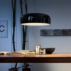 a wooden table topped with a lamp and pictures