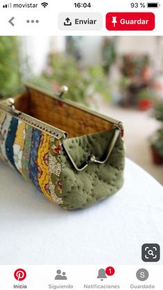 a small purse sitting on top of a white table next to potted planters