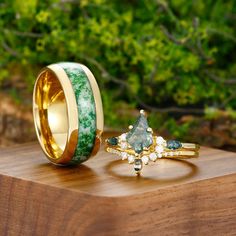 two rings with green and white marbles on them sitting on top of a wooden table