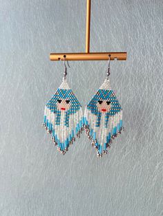 the beaded earrings are hanging from a wooden hanger