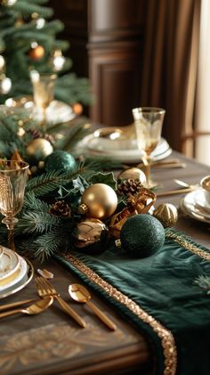 a christmas table setting with green and gold decorations