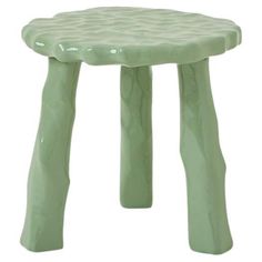 a small green stool sitting on top of a white floor