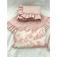 two pillows and a pillow case on a white sheet with pink gingham fabric