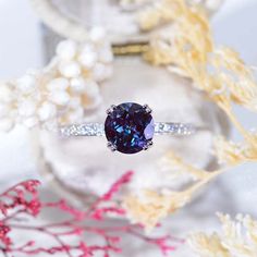 a ring with a blue diamond surrounded by flowers