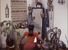 a woman sitting on the floor in front of a mirror