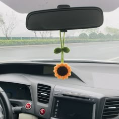 a car dashboard with a sunflower attached to the dash board